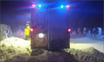  ??  ?? The ambulance stuck in the snow outside Ardee and right, HSE Ambulance personnel try to free their amubalnce from the snow.