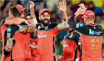  ??  ?? Royal Challenger­s Bangalore captain Virat Kohli (centre) celebrates the fall of a wicket with his teammates in this file photo.