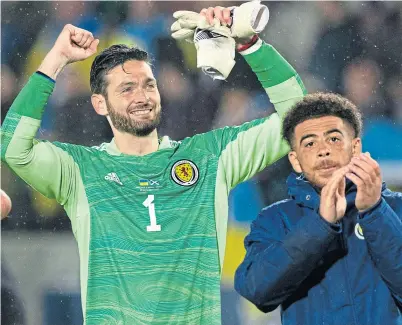  ?? ?? Hearts and Scotland No. 1 Craig Gordon celebrates Nations League success with Che Adams, following a clean sheet against Ukraine in Poland in September