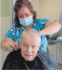  ?? FAIRHAVEN ?? Fairhaven resident Ray Davis gets his hair cut by Heather Smith, one of the staff members who stepped up to give haircuts when the regular hairdresse­r was unable to visit during the lockdown.