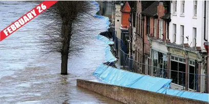  ??  ?? Last defence...barriers were put up to save properties in the town after the water levels rose beyond 22ft