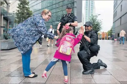  ??  ?? MUCHA SEGURIDAD. Una niña simpatiza con la policía que patrulla la ciudad. La zona de la bahía va tomando forma y la UEFA ha instalado campos flotantes.