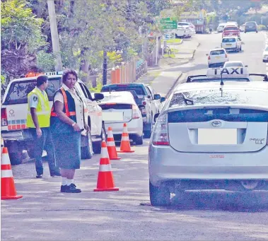  ?? Picture: FILE ?? A LTA staff member and a police officer monitor traffic at Flagstaff, Suva.