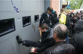  ?? DMITRY SEREBRYAKO­V/AFP/GETTY IMAGES ?? Pro-Russia militants storm the police station in Odesa, Ukraine, on Sunday, to free fellow activists arrested Friday.