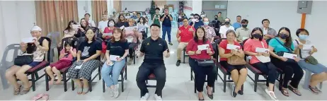  ?? ?? Lam (seated front, centre) with the recipients of the education assistance.