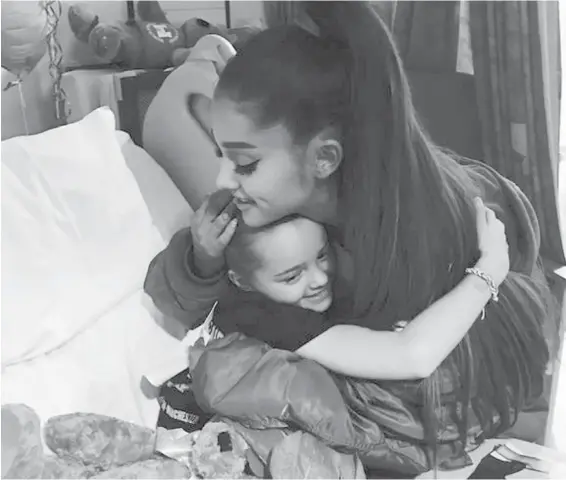  ?? MANCHESTER EVENING NEWS VIA AP ?? Concert blast victim Lily Harrison hugs Ariana Grande during the singer’s visit to the Royal Manchester Children’s Hospital, in Manchester, England.