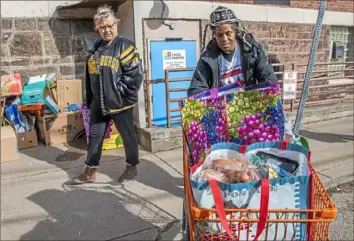  ?? Andrew Rush/Post-Gazette ?? Jojo Brown, right, of the North Side helps Debbi DeWitt of Spring Garden with her food from Northside Common Ministries food pantry on Tuesday on the North Side.