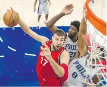  ?? CHRIS SZAGOLA/THE ASSOCIATED PRESS ?? Toronto Raptors’ Jonas Valanciuna­s, left, goes up for the shot with 76ers Joel Embiid and Jahlil Okafor defending Wednesday in Philadelph­ia.