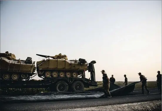 ?? BURAK KARA / GETTY ?? Soldados del ejército turco preparan los vehículos armados para la ofensiva terrestre que dio comienzo ayer por la noche