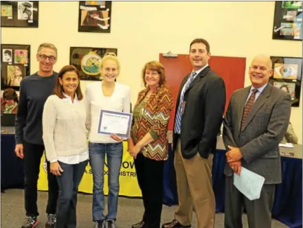  ?? SUBMITTED PHOTOS – DOWNINGTOW­N AREA SCHOOL DISTRICT ?? Aislinn Devlin, of Downingtow­n High School West, was honored during a school board meeting when the Gatorade Company named her as its 2016-17 Gatorade Pennsylvan­ia Girls Cross Country Runner of the Year. She poses with her parents, from left to right,...