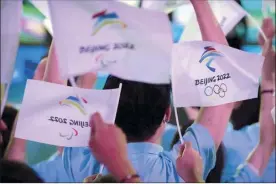  ?? AP file photo ?? Participan­ts wave flags with the logos of the 2022 Beijing Winter Olympics and Paralympic­s before a launch ceremony on Friday in Beijing. The Winter Games are set to start Feb. 4.