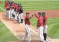  ?? ROB SCHUMACHER/THE REPUBLIC ?? D-Backs left fielder David Peralta (6) fist-bumps manager Torey Lovullo during the spring training opener Sunday at Salt River Fields at Talking Stick.