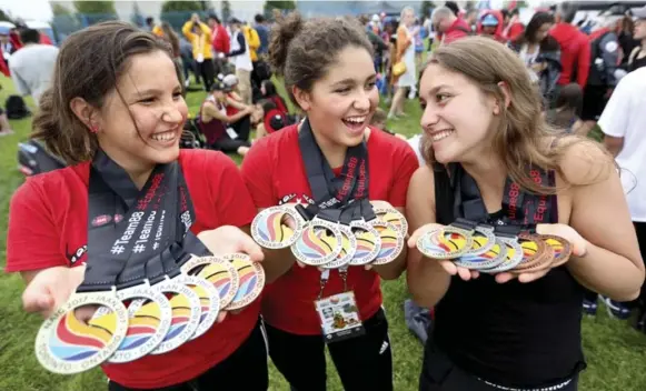  ?? RICHARD LAUTENS PHOTOS/TORONTO STAR ?? Yukon swimmers, from left, Kassua Dreyer, 12, Rennes Lindsay, 14 and Cassis Lindsay, 16, show off their medal haul at the closing ceremony Saturday night.