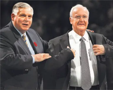  ?? DAVID COOPER/TORONTO STAR ?? Murray Costello, right, tries on his Hockey Hall of Fame jacket for size after it was presented to him by Bill Hay, chairman and CEO of the hall, at the Canada versus Russia legends game at the Air Canada Centre yesterday.