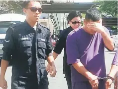  ??  ?? Police personnel escorting the GOF man to Miri court for remand applicatio­n.