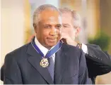  ?? AP FILE ?? In November 2005, President George W. Bush awards the Presidenti­al Medal of Freedom Award to Frank Robinson during a White House ceremony.