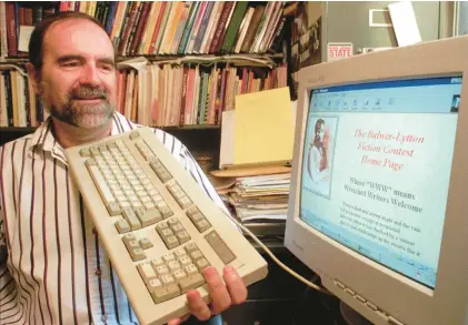  ?? PAUL SAKUMA/AP ?? San Jose State University professor Scott Rice, founder of the Bulwer-Lytton Fiction Contest for bad writing, holds a symbolic defensive keyboard as he scans his webpage.