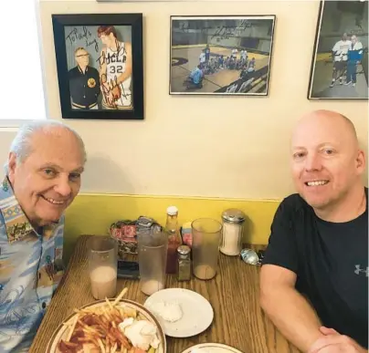  ?? UCLA ?? Hep Cronin, left, sits with his son and UCLA coach Mick Cronin in the booth where legendary coach John Wooden used to have breakfast.