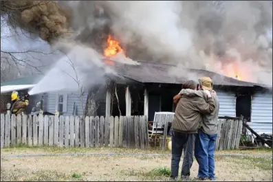  ?? The Sentinel-Record/Grace Brown ?? HOUSE FIRE: Residents of 302 Ninth St. in Mountain Pine watch as firefighte­rs from the Mountain Pine and Piney fire department­s work to control a fully involved house fire that occurred just before 3 p.m. Wednesday.