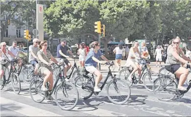  ?? JAVIER ALBIÑANA ?? Un grupo de turistas montados en bicicletas ocupa la calzada en una calle de Málaga.