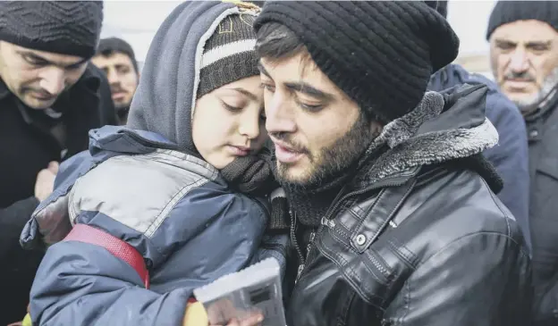  ?? PICTURE: AP ?? 0 Muhammed Salih, from Aleppo, and his son make the crossing into Turkey yesterday after they managed to leave the embattled Syrian city