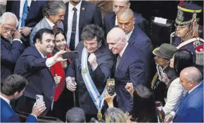  ?? Agustín Marcarina / Reuters ?? Milei posa para un selfi con otros políticos en el pleno del Congreso argentino, ayer.