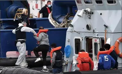  ?? Picture: BEN STANSALL/AFP/GETTY ?? CHANNEL CRISIS: Border Force officers help aboard migrants picked up at sea yesterday