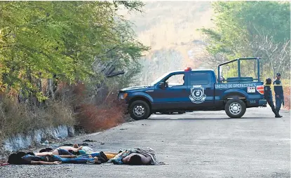  ??  ?? Policías cierran el paso en la carretera Mazatlán-Lagunillas donde fueron localizada­s las víctimas.