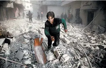  ?? AMER ALMOHIBANY/GETTY-AFP ?? A young Syrian runs following an airstrike in rebel-held Arbin in eastern Ghouta near the capital of Damascus. A Syrian Civil Defense official said 58 people were killed.