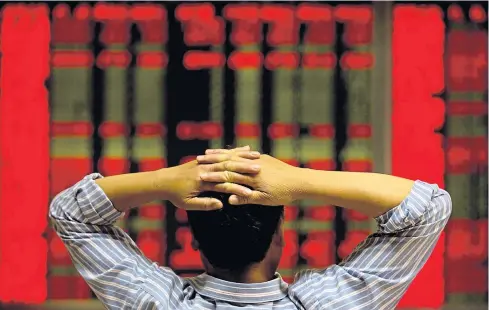  ??  ?? RED ALL OVER: A Chinese investor monitors stock prices from a brokerage house in Beijing. Efforts to arrest falling prices have shaken confidence in the government.