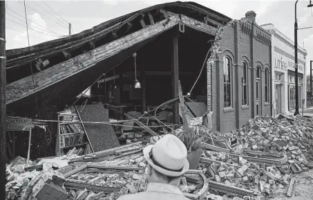  ?? John Locher / Associated Press ?? A man looks at a partially collapsed building Saturday in the aftermath of Hurricane Ida in Houma, La. Ida damaged or destroyed more than 22,000 power poles, more than Hurricanes Katrina, Zeta and Delta combined.