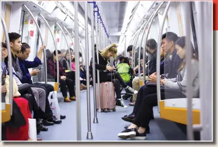  ?? Photo: VCG ?? A woman gazes at her cellphone in a subway carriage, indifferen­t to her surroundin­gs, in Shenzhen, Guangdong Province.