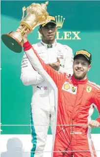  ?? EFE ?? Sebastian Vettel levanta el trofeo mientras era aplaudido por su gran rival Lewis Hamilton.