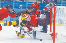  ?? FOTO: DPA ?? Umkämpftes Spiel: Yasin Ehliz (gelbes Trikot) macht Druck auf das Tor von Kanadas Goalie Kevin Poulin.