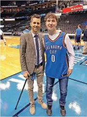  ?? [PHOTO PROVIDED] ?? Chris Fisher, Thunder play-by-play announcer, poses for a photo with Caleb Freeman, of Newcastle, before an Oklahoma City Thunder game at Chesapeake Energy Arena.