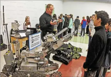  ?? CHRIS BARBER — DIGITAL FIRST MEDIA ?? A speaker at the Hopewell STEM Expo described and shows students how robotics and special equipment help law enforcemen­t SWAT teams capture a suspect safely.