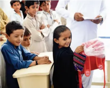  ??  ?? August 31, 2016: Students receive schoolbags and stationery donated by the CFPD at the ChinaPakis­tan Government Primary School in Faqeer Colony, Gwadar.