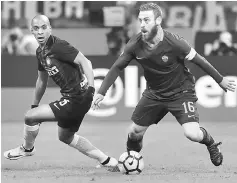  ??  ?? Roma’s midfielder from Italy Daniele De Rossi (right) fights for the ball with Inter Milan’s midfielder from Portugal Joao Mario during the Italian Serie A football match at the San Siro stadium in Milan in this Feb 26 file photo. — AFP photo