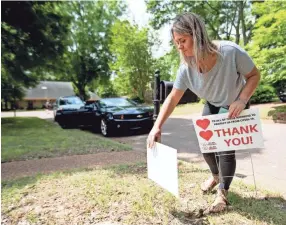  ?? MAX GERSH / THE COMMERCIAL APPEAL ?? Averi Davis places a thank-you sign in a yard Tuesday, April 28, 2020, in Germantown.