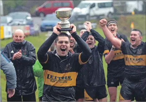  ?? Photograph: Abrightsid­e Photograph­y. ?? Lochaber captain Callum MacDonald lifts the trophy amid scenes of jubilation at a wet but happy Banavie on Saturday.