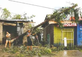  ?? AP PHOTO/AARON FAVILA ?? A resident picks up pieces from a tree toppled by strong winds from Typhoon Mangkhut as it barreled across Tuguegarao city in Cagayan province, northeaste­rn Philippine­s.