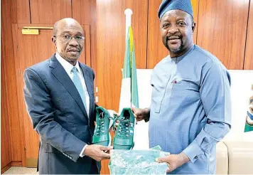  ??  ?? CBN Governor, Godwin Emefiele and Minister of Youth and Sports Developmen­t, Sunday Dare showcasing Team Nigeria’s Tokyo Olympics outfits when the CBN Governor visited the Minister in his office in Abuja