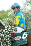  ?? Associated Press ?? Jockey Victor Espinoza poses with American Pharoah in the winner’s circle after winning the $1 million Arkansas Derby horse race April 11 at Oaklawn Park in Hot Springs, Ark.