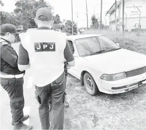  ?? ?? JALANKAN TUGAS: Pegawai JPJ Cawangan Miri sedang memeriksa lesen pemandu dalam operasi harian di KM2 Jalan Marudi, Sabtu lalu.