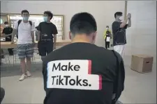  ?? NG HAN GUAN — THE ASSOCIATED PRESS ?? A man wearing a shirt promoting TikTok is seen at an Apple store in Beijing on Friday, July 17, 2020.