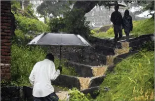  ?? THOKO CHIKONDI - THE ASSOCIATED PRESS ?? People brave the wet weather in Blantyre, Malawi, on Tuesday. Cyclone Freddy struck Africa for a second time on Saturday night.