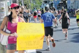  ?? JOE GIBBONS ?? Cheryl Andrews of the Bay Roberts Sole Sister running group cheers her team runners during the Tely 10 Sunday morning in St. John’s.