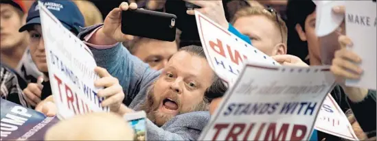  ?? Jeff Swensen Getty I mages ?? DONALD TRUMP supporters seek their candidate’s autograph in Cleveland, a day after a Chicago campaign rally was canceled amid angry confrontat­ions.