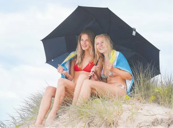  ?? Picture: MIKE BATTERHAM ?? It’s not great beach weather at the moment however Madonna Tax, 19, (left) and Tarnia McGuire, 20, were prepared at Currumbin yesterday.