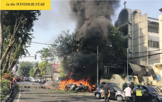  ?? SURABAYA GOVERNMENT HANDOUT/ANDY PINARIA/GETTY IMAGES ?? Flames pour out of the Surabaya Pantekosta Centre Church, the scene of one of three bomb blasts which targeted churches in Indonesia’s second-largest city on Sunday. At least 13 people were killed, including the bombers themselves. Officials said the...